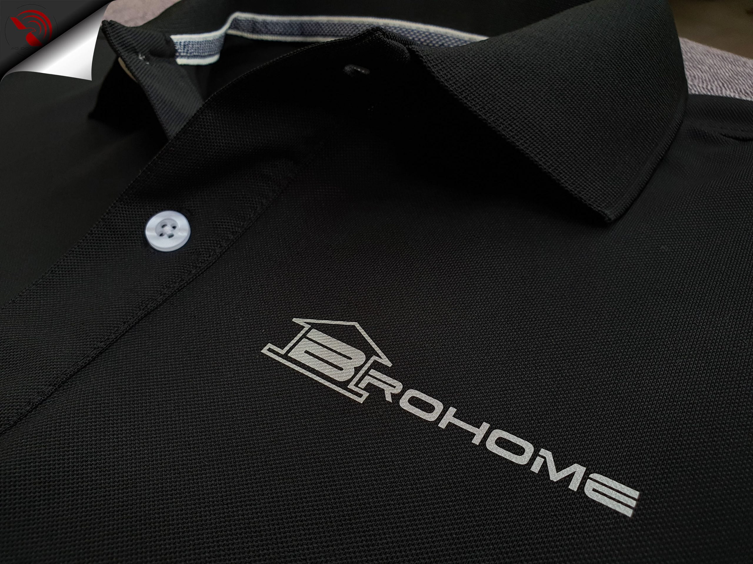 Hình in phản quang logo lên áo thun đồng phục polo bo trơn màu đen