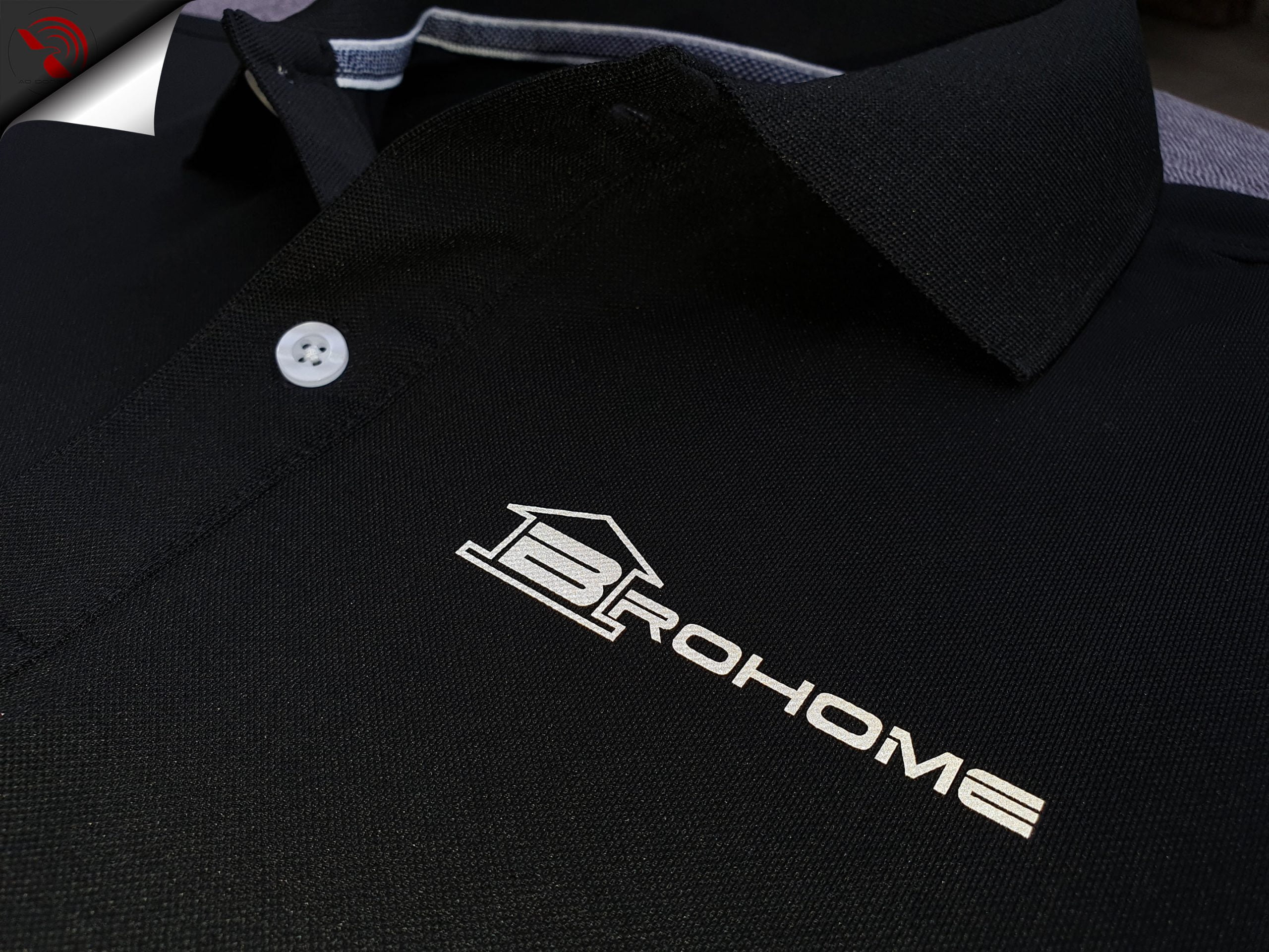Hình in phản quang logo lên áo thun đồng phục polo bo trơn màu đen