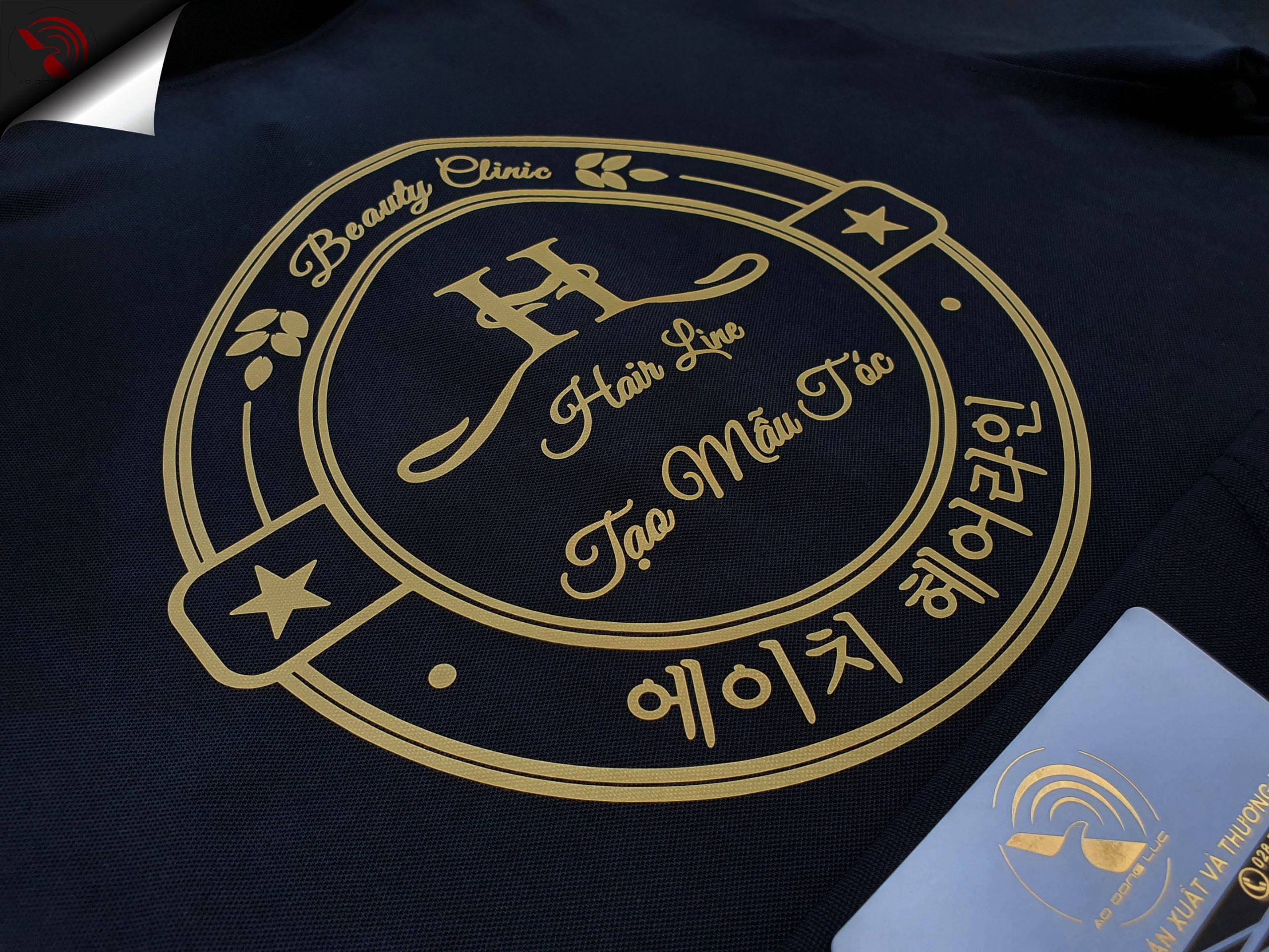 Hình in decal vàng đồng lên áo thun đồng phục polo đen