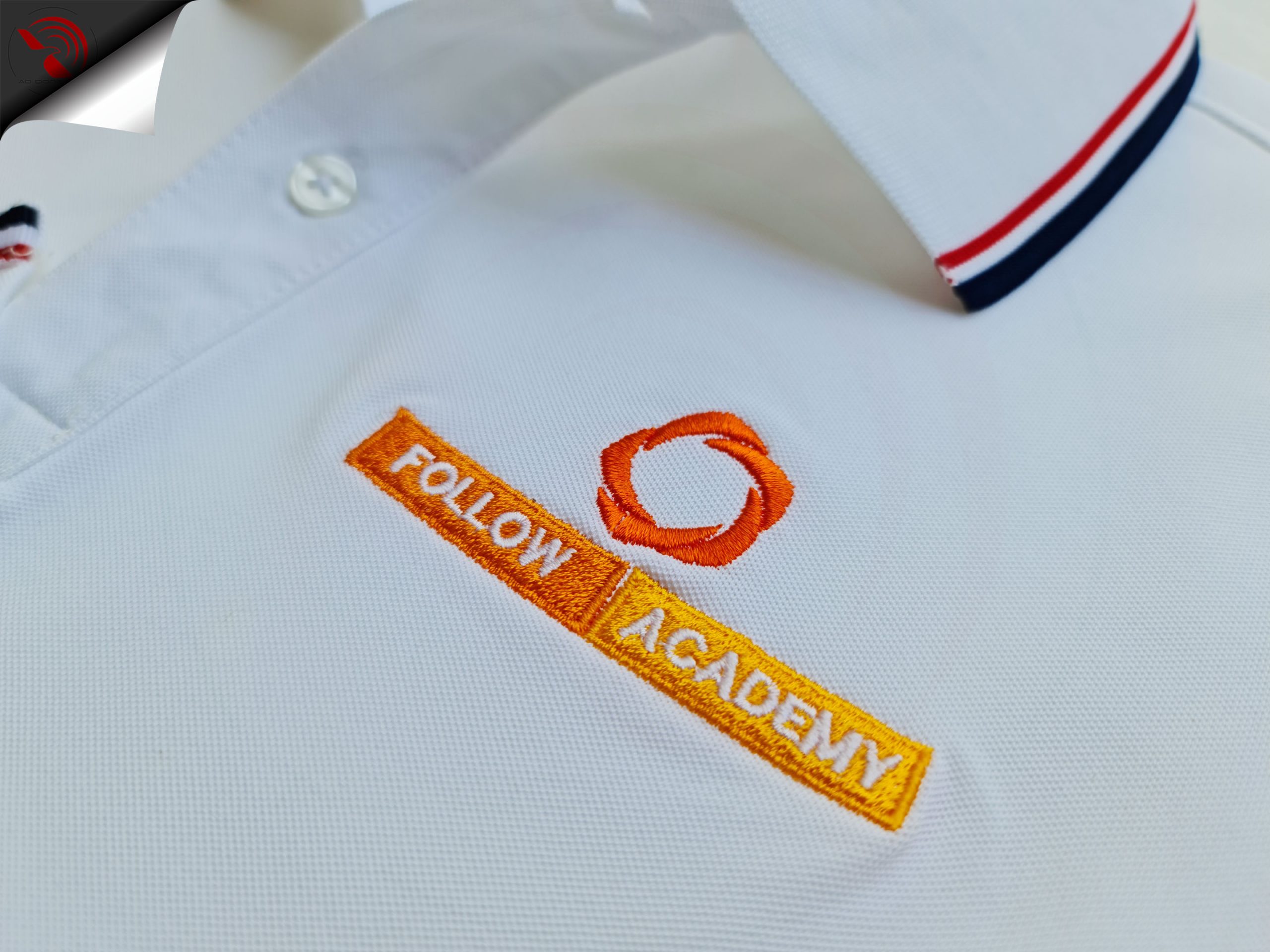 Hình thêu logo lên áo thun đồng phục polo bo sọc màu trắng